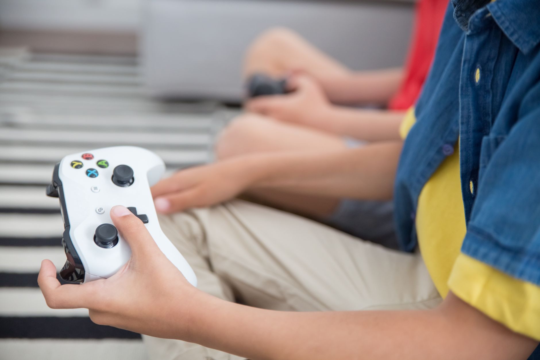 enfant tenant une manette de jeu vidéo, concentré devant l'écran