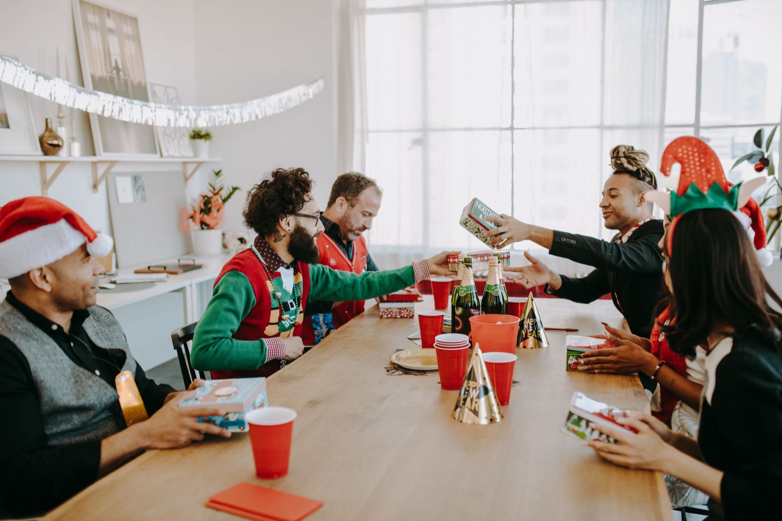 Des salariés ouvrent des boîtes cadeaux de Noël au bureau