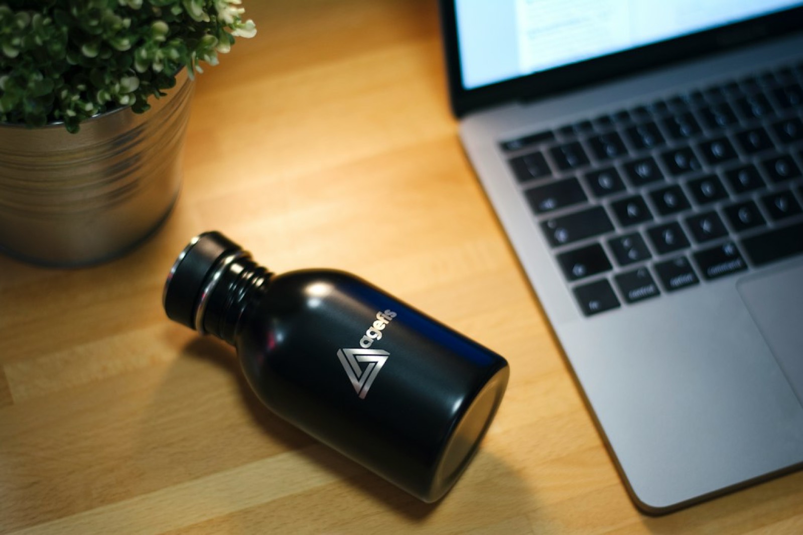 Gourde isotherme personnalisée avec un logo d'entreprise posée sur un bureau