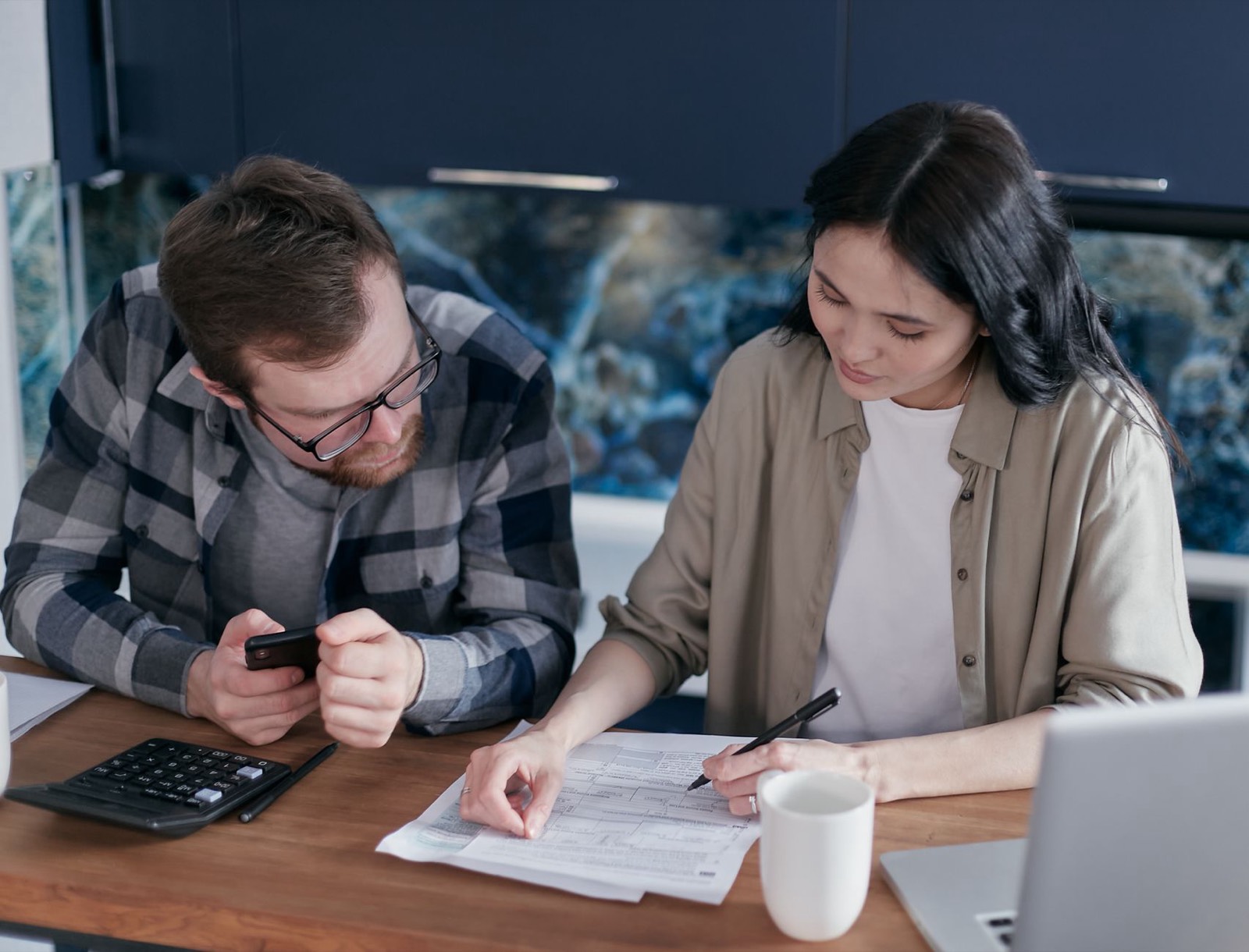 Un couple examine un contrat de financement automobile sur une table de salon