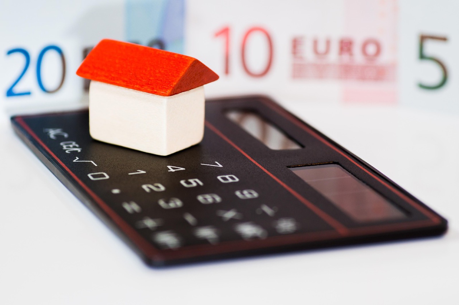 Calculatrice et documents de budget étalés sur une table pour préparer un dossier de prêt