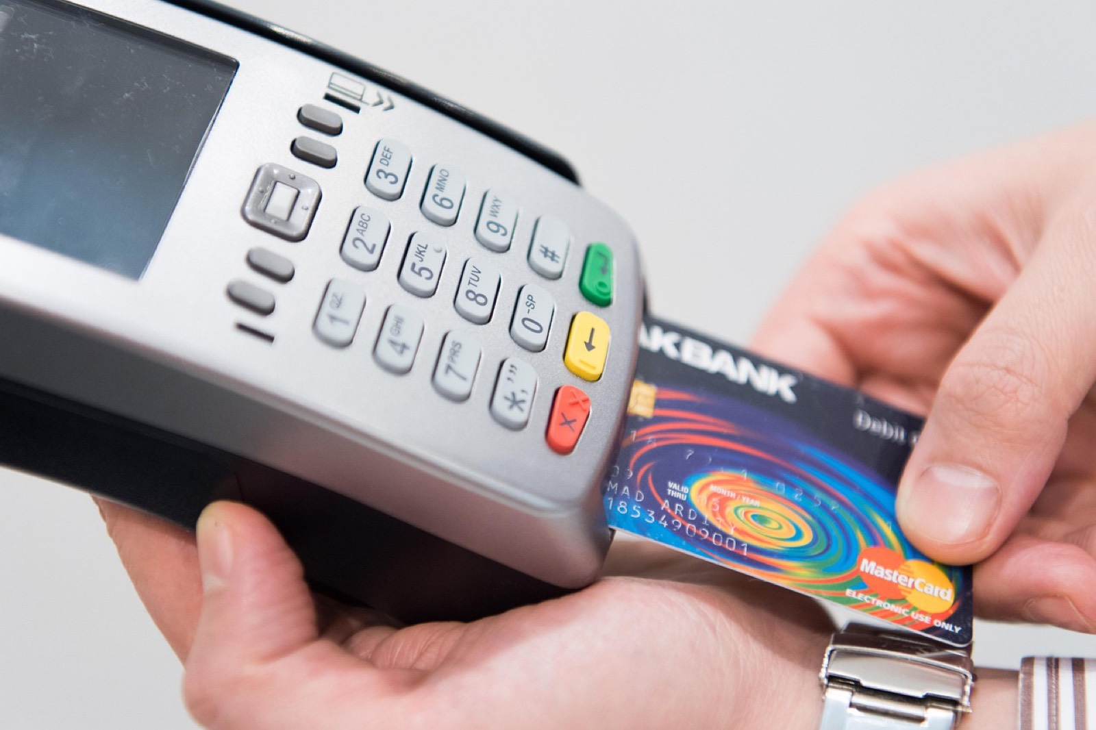 Terminal de paiement par carte présenté sur le pas d'une porte lors d'une livraison